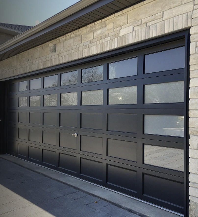 Black garage door with glass panels on a stone-faced home